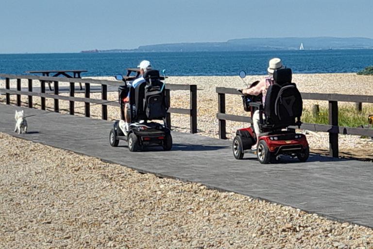 Two people in mobility scooters using the boardwalk